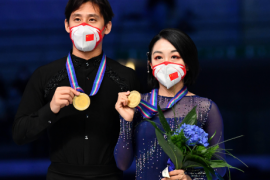 双人滑冠军组合隋文静韩聪在颁奖仪式后展示金牌